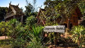 Una casa rustica chiamata 'Crossroads House' con un cartello che indica la sua fondazione nel 2007.