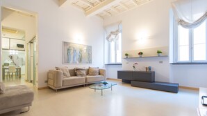 A spacious living room with a sofa, coffee table, and a painting on the wall. - Purificazione Hi-Tech Apartment (Rome)
