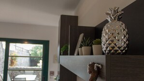 A shelf with a decorative pineapple, a small potted plant, and a wooden sculpture. - Villa Leonard in Playa Blanca (Playa Blanca)
