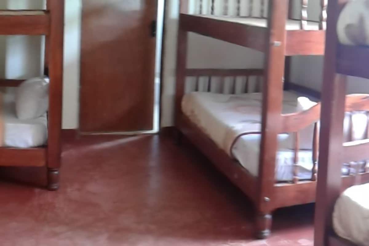 A room with bunk beds, wooden furniture, and a patterned floor.