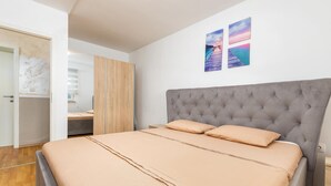 A bedroom with a large bed, a wooden wardrobe, and a desk. - Awesome home in Fazana (Fazana)