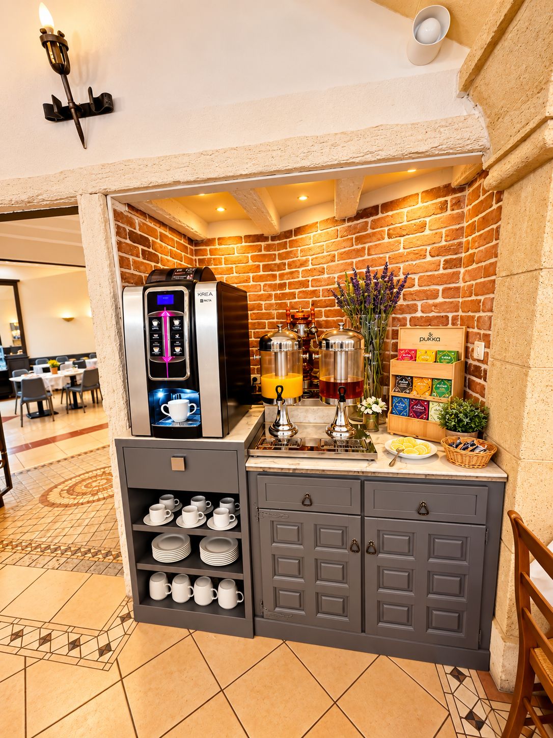 A compact coffee station with a coffee machine, tea dispensers, and a selection of tea bags.