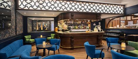 A bar area with a counter, seating, and a decorative wall.