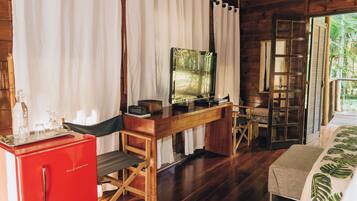 Un intérieur en bois avec un bureau, un téléviseur et un réfrigérateur rouge.