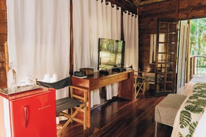 Un intérieur en bois avec un bureau, un téléviseur et un réfrigérateur rouge.