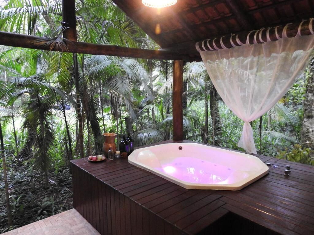 Tinaco en un entorno tropical con una terraza de madera y una pérgola.