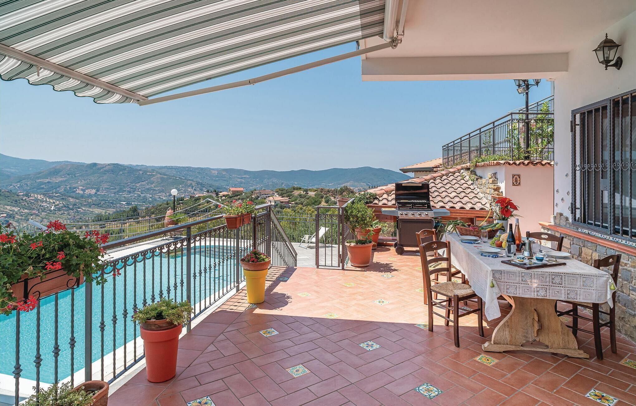 A terrace with a pool, outdoor seating, and a view of the mountains.