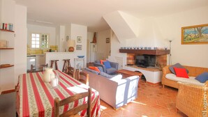 Un amplio espacio de sala de estar con mesa de comedor, sofás y chimenea.