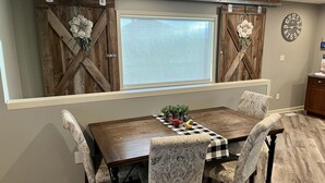Un coin repas avec une table en bois, des chaises à motifs et une nappe à carreaux.