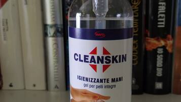 Pullo Cleanskin-käsihuuhdetta hyllyllä, jossa on myös kirjoja.