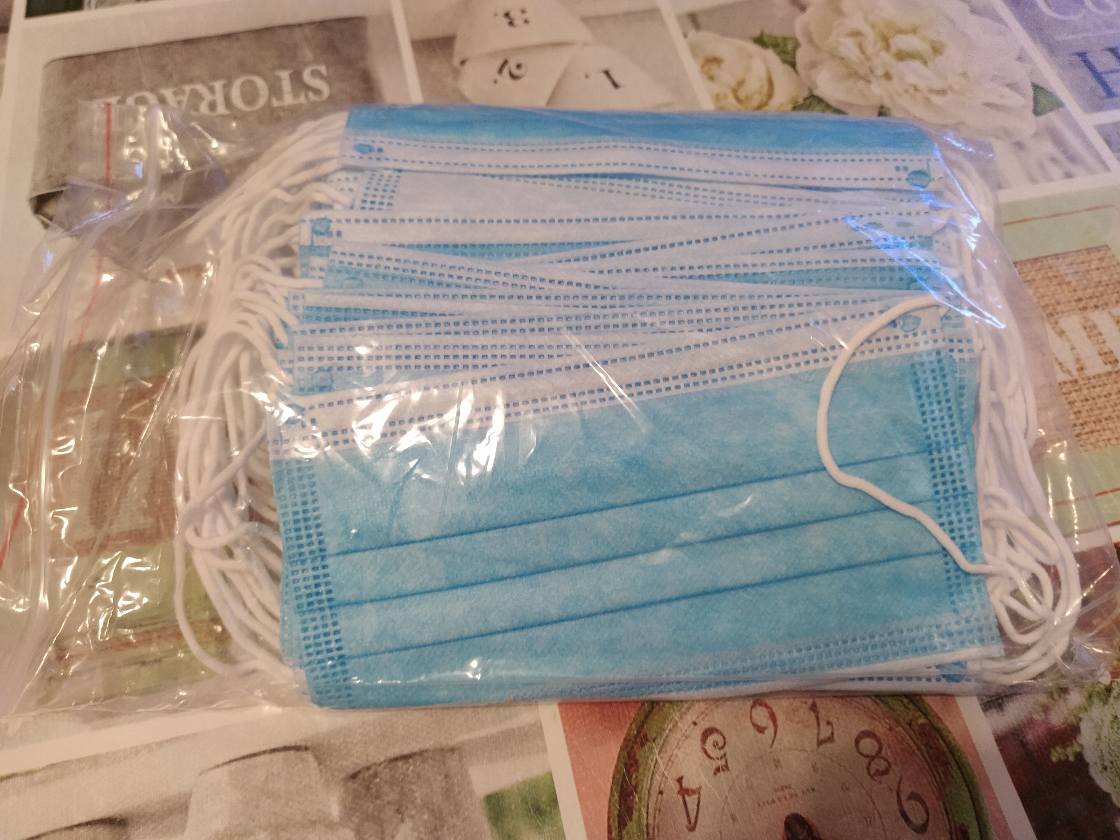 Una bolsa de plástico con varias mascarillas quirúrgicas azules.