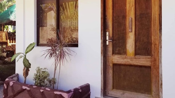 A white building with a wooden door and a window. - Talisay Point Homes (Moalboal)