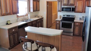 Una cocina con armarios de madera, estufa de acero inoxidable y lavavajillas.