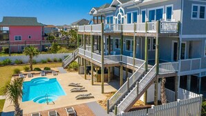 A multi-story beachfront property with a swimming pool, outdoor seating, and a covered deck area. - Experience oceanfront luxury at Topsail Manor, a spacious 8-bedroom paradise in North Topsail Beach. (North Topsail Beach)