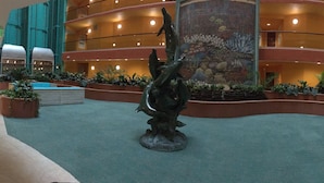 A spacious lobby with a central sculpture, multiple floors, and indoor plants. - Resort Style Amenities. NO extra admin fees added. Amazing parking spot!  (Orange Beach)