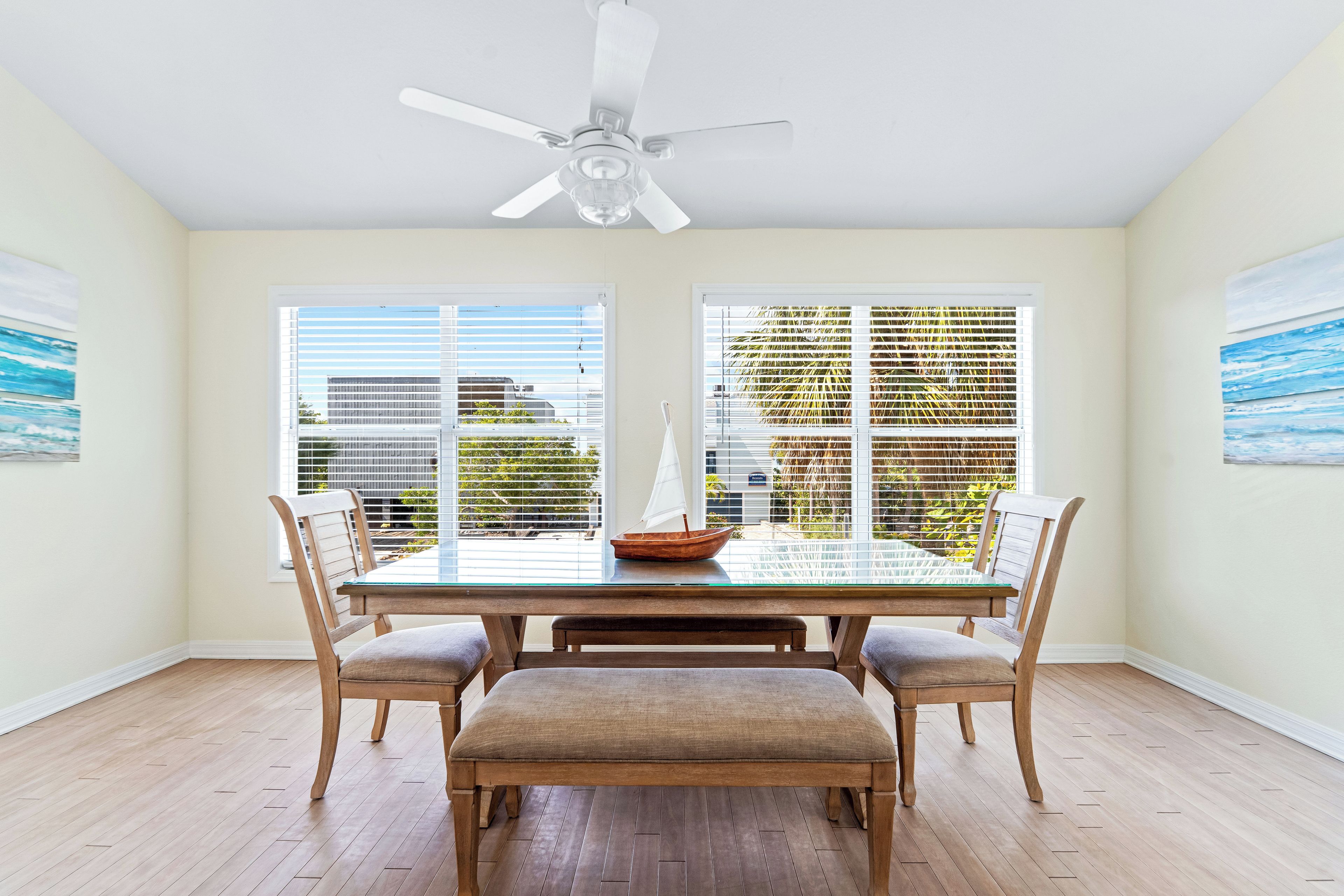 A dining area with a table, chairs, and a ceiling fan.