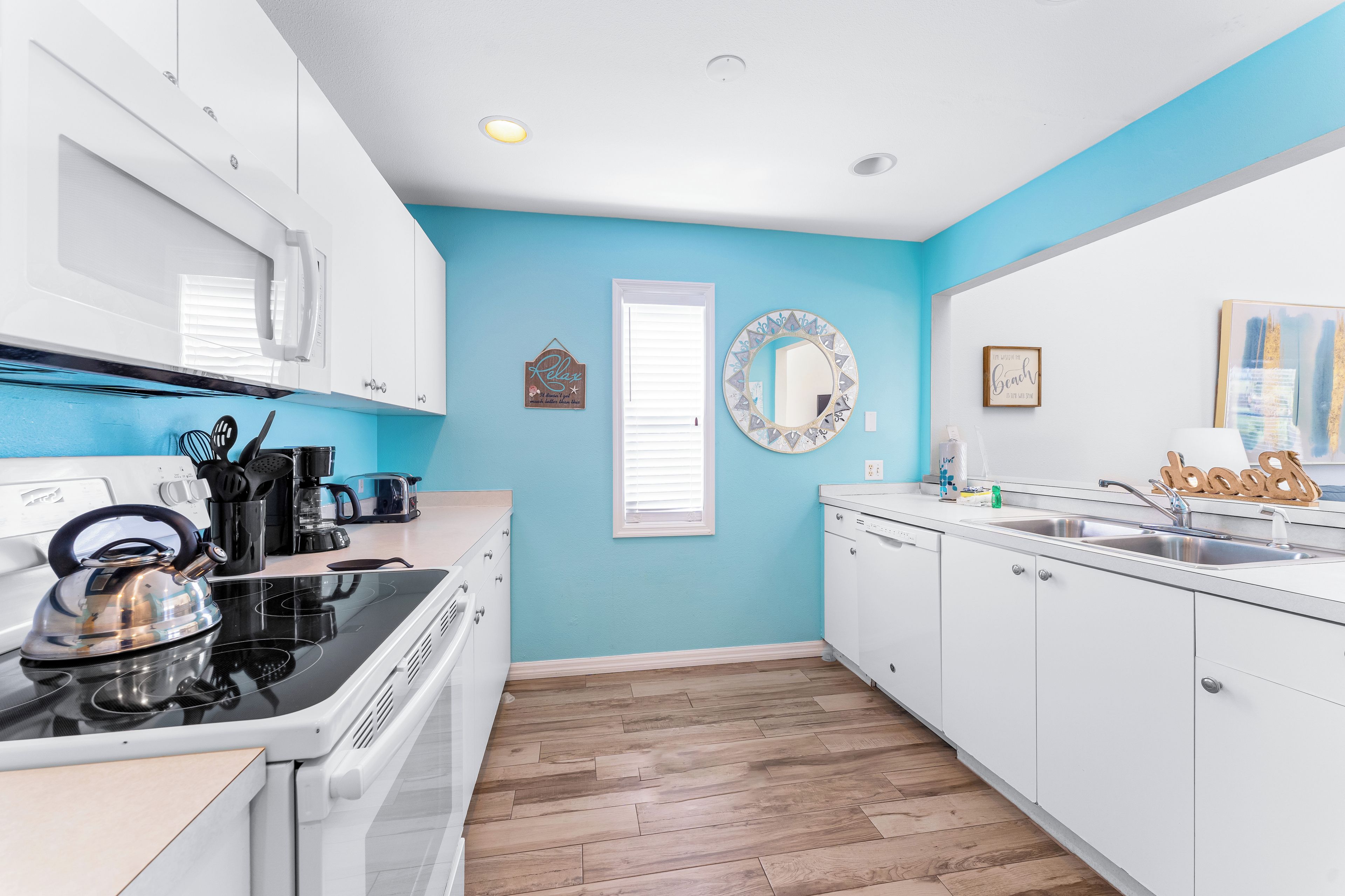 A kitchen with white cabinets, a stove, and a sink.