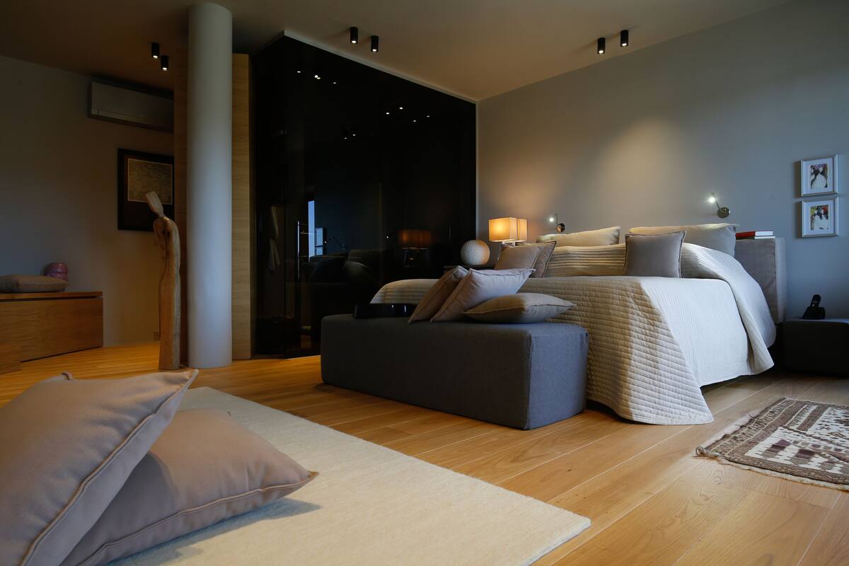 Une chambre moderne avec un grand lit, un canapé et une table de chevet.