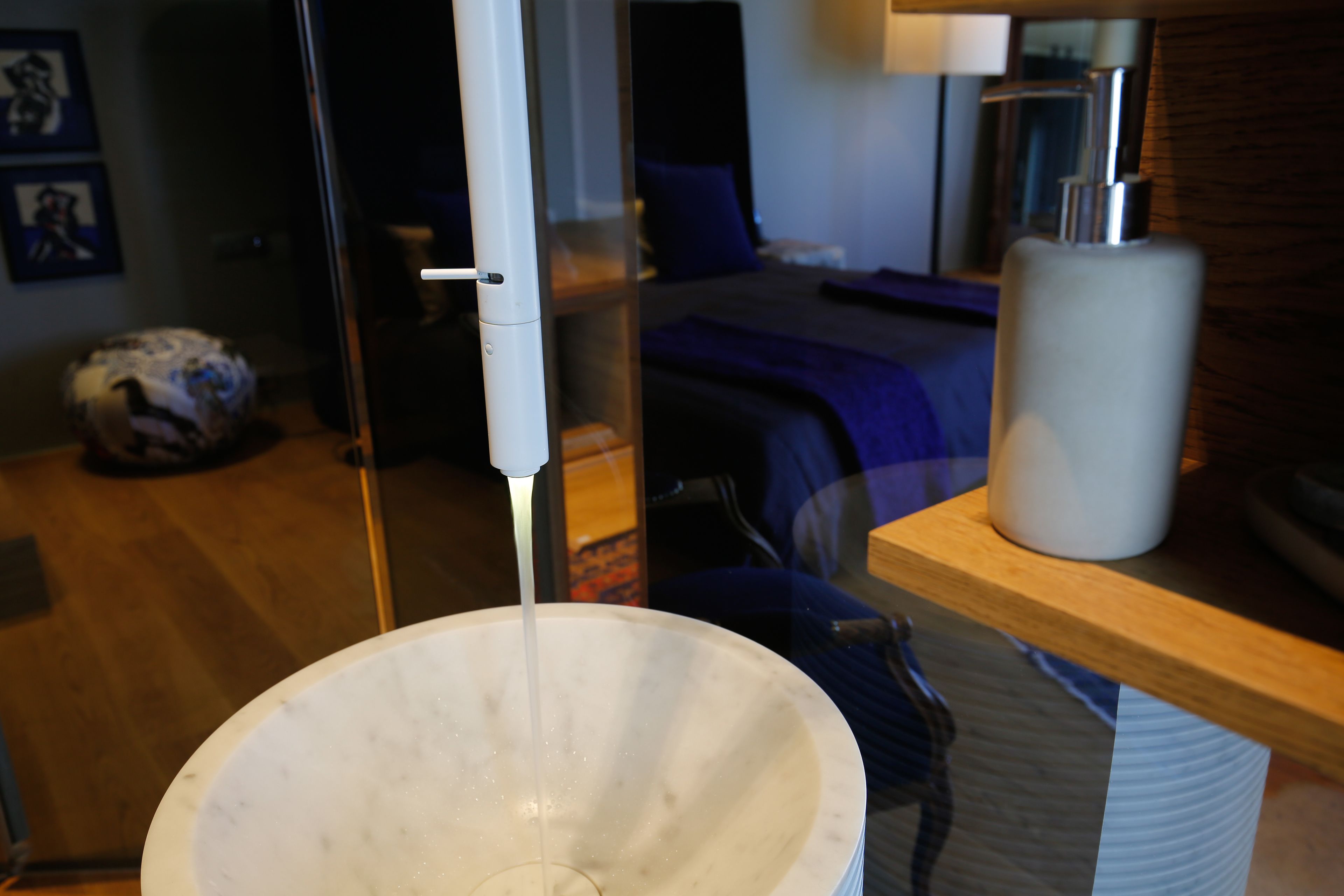 Een badkamer met een groot wit wastafel, een spiegel en een houten aanrecht.