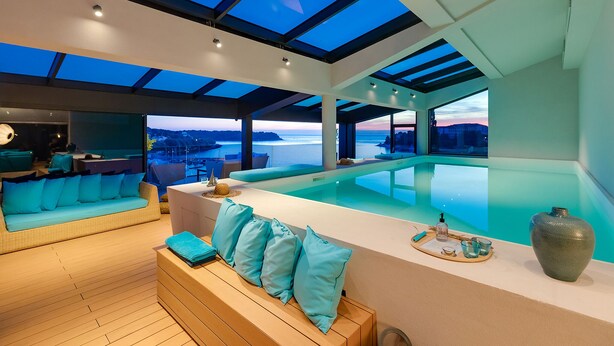 A modern interior with a pool, a sofa, and a dining area. - Hotel Valsabbion (Medulin)