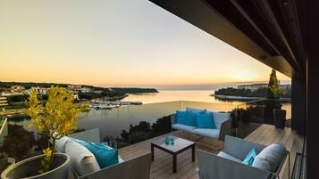 Un balcón con vista a un puerto deportivo y al atardecer.