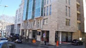 A multi-story building with a modern architectural design, featuring large windows and a stone facade. - Rustaveli Besiki Apartments (Tbilisi)