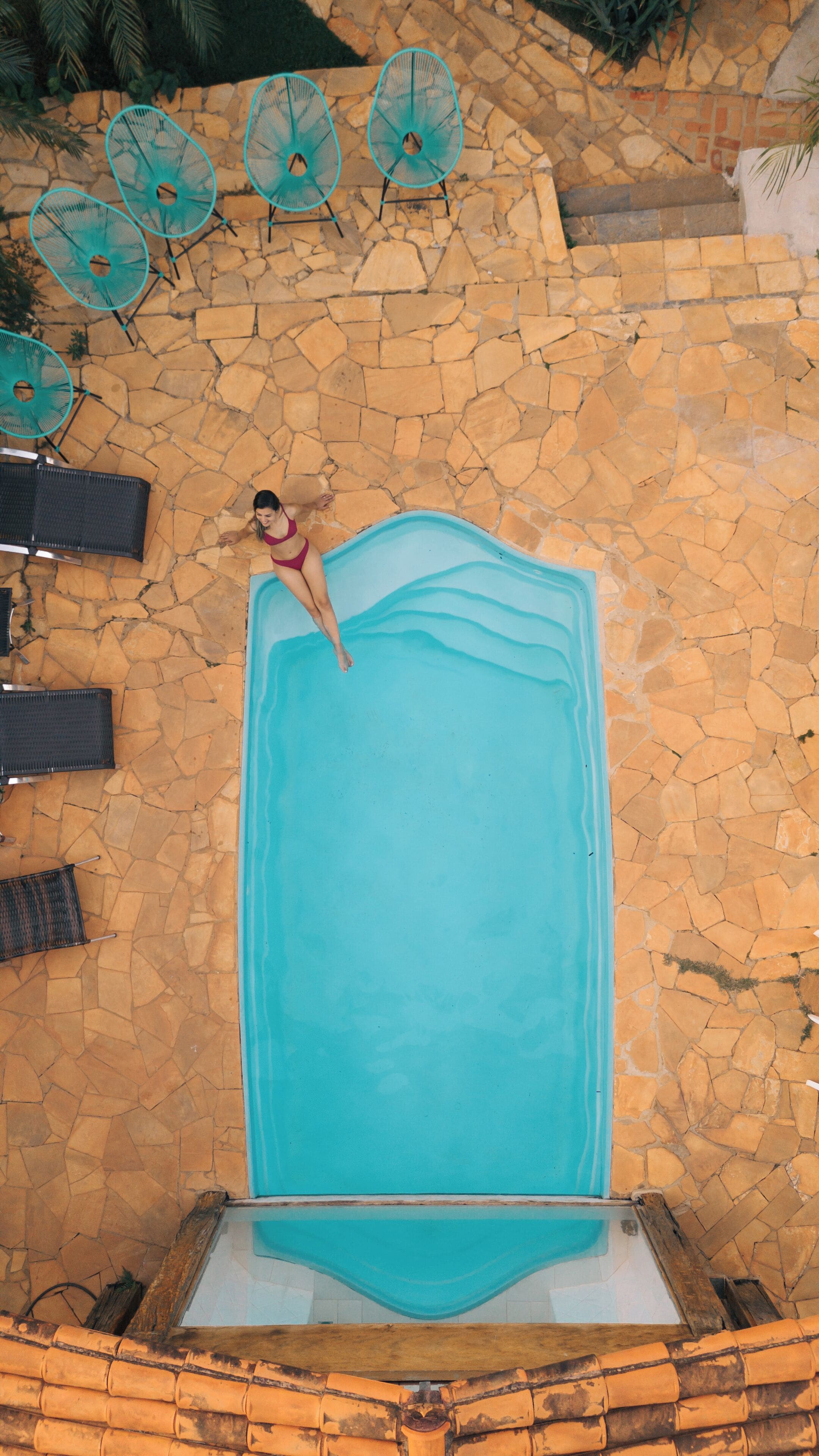 Una piscina interior amplia con un muro de piedra alrededor.