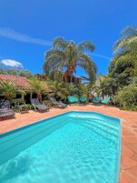 Una piscina al aire libre, sillones reclinables de piscina