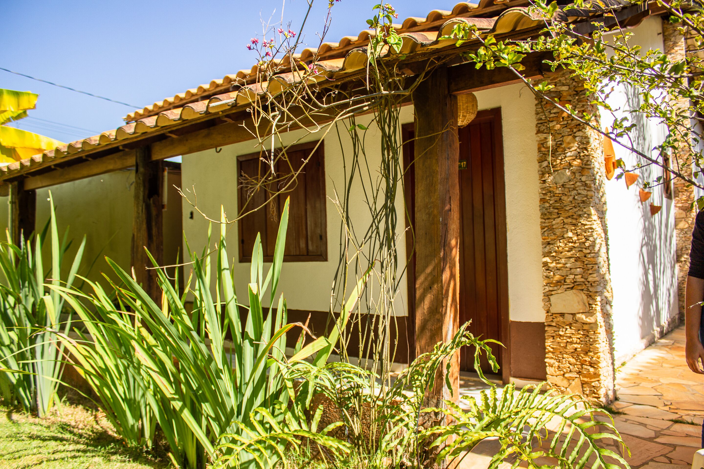 A building with a tiled roof, wooden beams, and a stone wall.