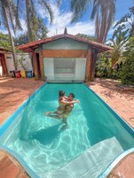 Una piscina al aire libre, sillones reclinables de piscina