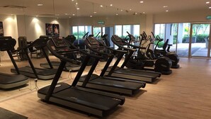 Kuntosali, jossa on useita vierekkäin riveihin asetettuja juoksumattoja, suuret ikkunat ja siisti, moderni sisustus.
