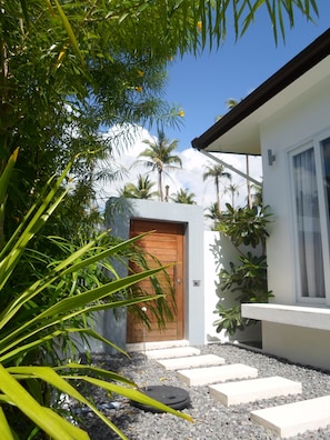 Enter a serene oasis with a garden and lush greenery surrounding this stylish residence.