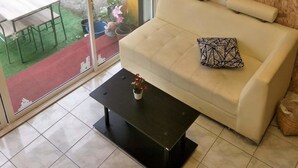 Ein modernes Wohnzimmer mit einem weißen Sofa, einem schwarzen Couchtisch und einer Chandeliebre.