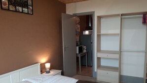 Une chambre à coucher avec un lit, une lampe de chevet et une armoire.