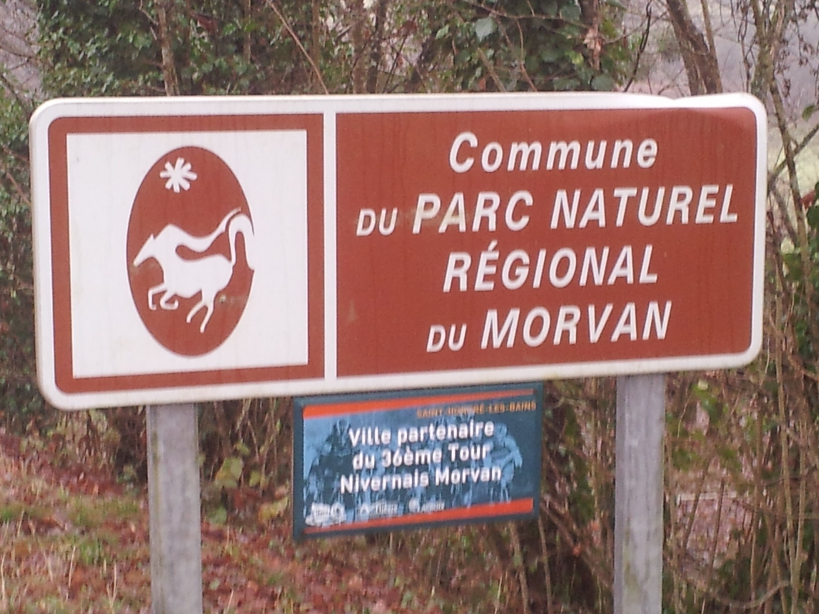 A sign with text and a logo, likely indicating a location or area of interest.
