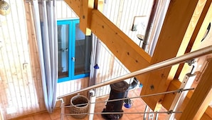 A wooden staircase with metal railings, leading to a room with a blue door and a window. - Near Soulac-sur-Mer, 6-bedroom villa with heated indoor pool, jacuzzi, and sauna (Grayan-Et-L'hôpital)