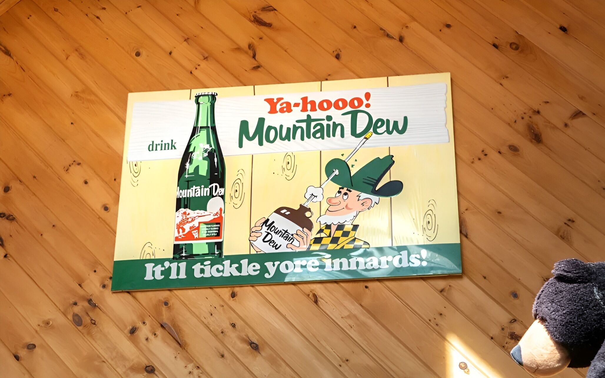 Una pared de madera con un cartel que anuncia Mountain Dew.