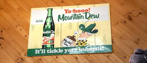 Una pared de madera con un cartel que anuncia Mountain Dew.