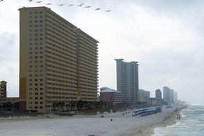 A beachside hotel with multiple floors, a sandy beach, and a view of the ocean. - Calypso unit 601 - Oceanfront 2 King bds, BEACH CHAIRS, 2 recliners. (Panama City Beach)