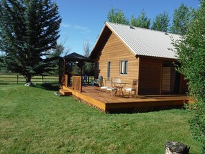A wooden cabin with a deck, outdoor seating, and a large tree nearby. - 10.7 mi to Targhee Ski resort, 360inch snow, This is your Favorite Place 2 stay (Driggs)