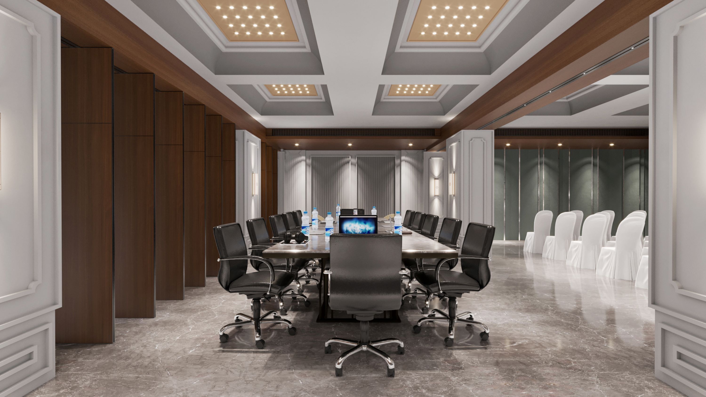 A conference room with a long table, black chairs, and a large screen at the front.