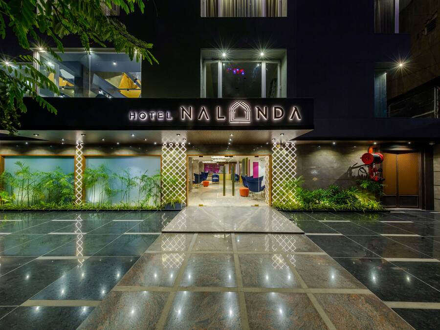L'esterno dell'Hotel Nalonda, con un ingresso moderno, insegne illuminate e una curata area giardino.