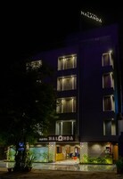 A modern hotel building at night with illuminated signage reading "Hotel Nalanda."