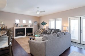A living room with a fireplace, sofa, and television. - Prime Downtown Location, Walk to the Beach! Home Away from Home! (Pismo Beach)