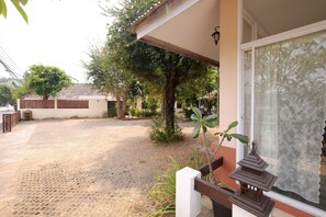 Un patio con zona pavimentada, cerca de madera y un farol de estilo pagoda tradicional.
