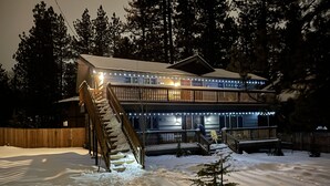 A two-story lodge with a snow-covered deck and a staircase leading to the entrance. - Walking distance to Snow Summit Resort. (Big Bear Lake)