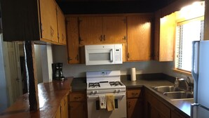 A kitchen with wooden cabinets, a microwave, a gas stove, and a sink. - Walking distance to Snow Summit Resort. (Big Bear Lake)