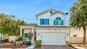 A two-story house with a garage, a covered porch, and a brick driveway. - Why stay in the confinement of a hotel,when you can stay in this Las Vegas oasis (Las Vegas)