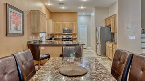 A modern kitchen with wooden cabinets, stainless steel appliances, and a marble countertop. - Why stay in the confinement of a hotel,when you can stay in this Las Vegas oasis (Las Vegas)