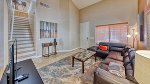 A living room with a staircase, a sofa, a coffee table, and a TV. - Why stay in the confinement of a hotel,when you can stay in this Las Vegas oasis (Las Vegas)